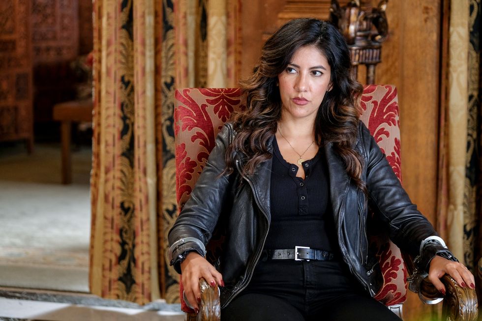 rosa diaz, played by stephanie beatriz, sits in an armchair during an episode of brooklyn nine nine