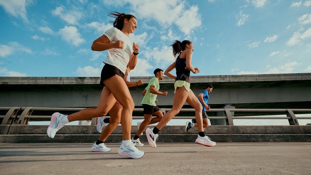 Group of runners exercising outdoors on a concrete surface under a bridge