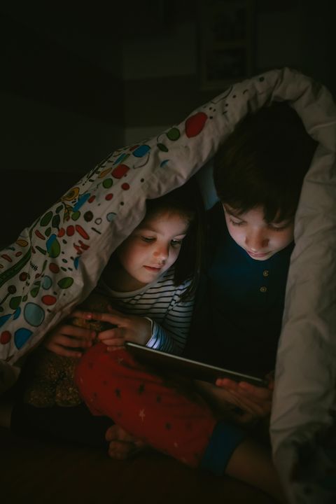 brothers looking at the tablet in the dark