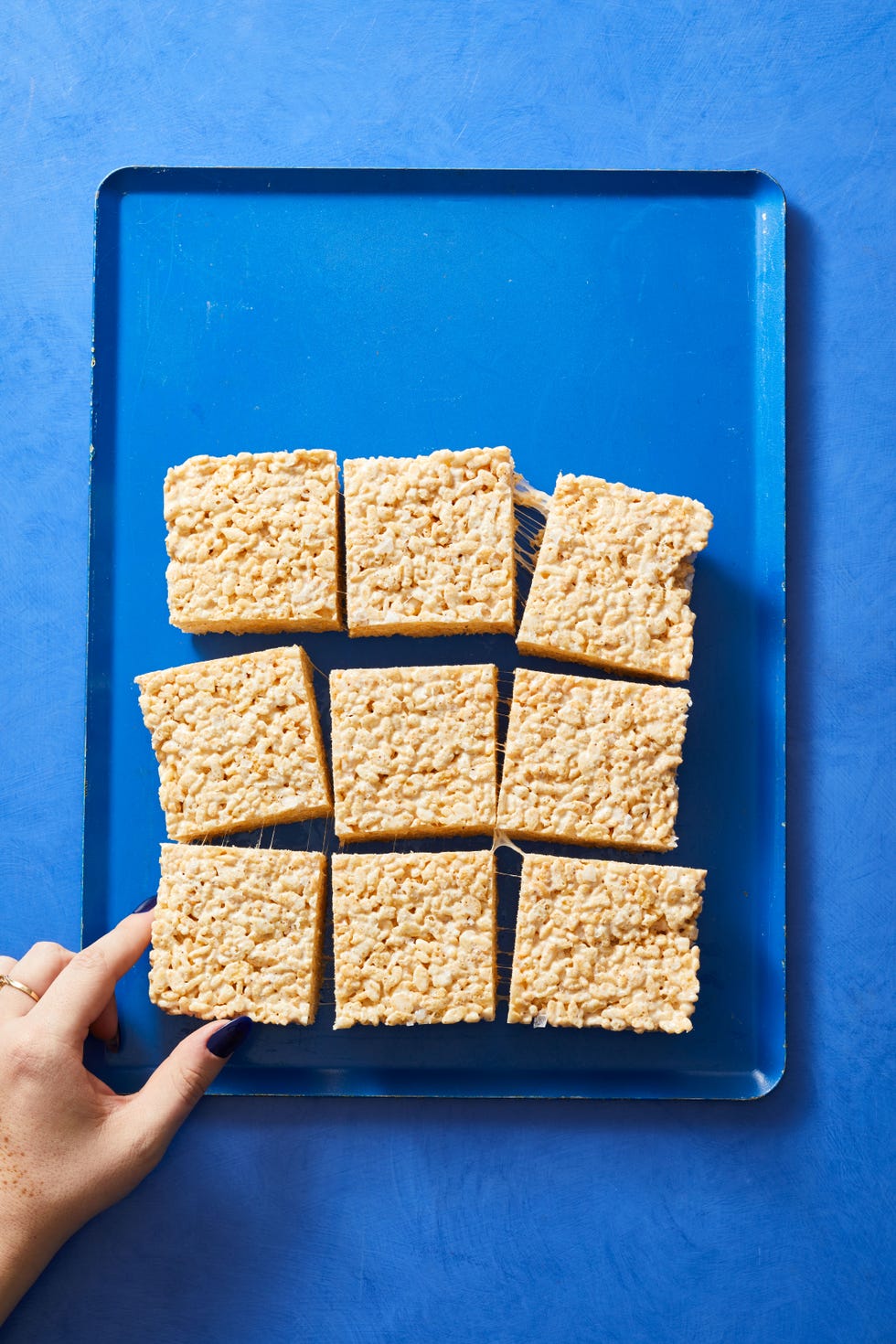 rice crispy treats cut into squares on a blue background