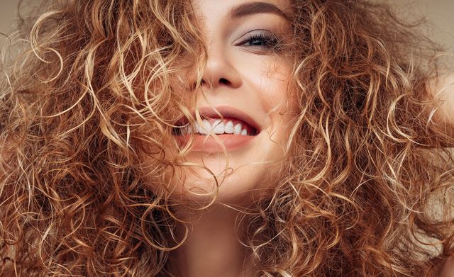 mujer pelo rizado castana