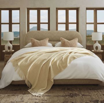 a light filled bedroom with neutral sheets