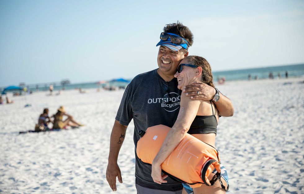 bruce mccarthy gets a hug from triathlete sally smith during a tuesday night open water swim at clearwater beach tuesday may 25th, 2021