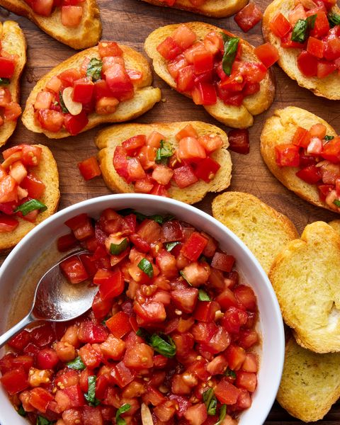 bruschetta spooned on top of slices of a toasted baguette