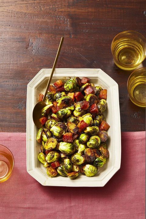 brussels sprouts with heaps of bacon on a white platter