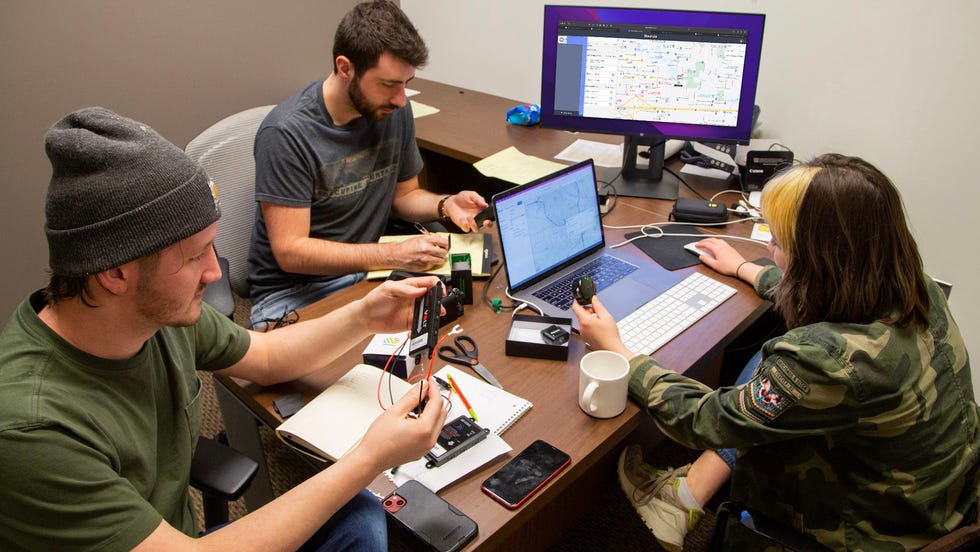 best gps trackers 3 people testing the best gps trackers in an office