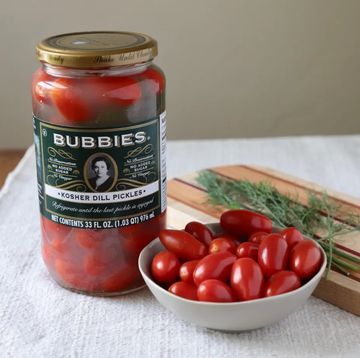 jar of cherry tomatoes in bubbies pickle jar with brine next to a bowl of cherry tomatoes
