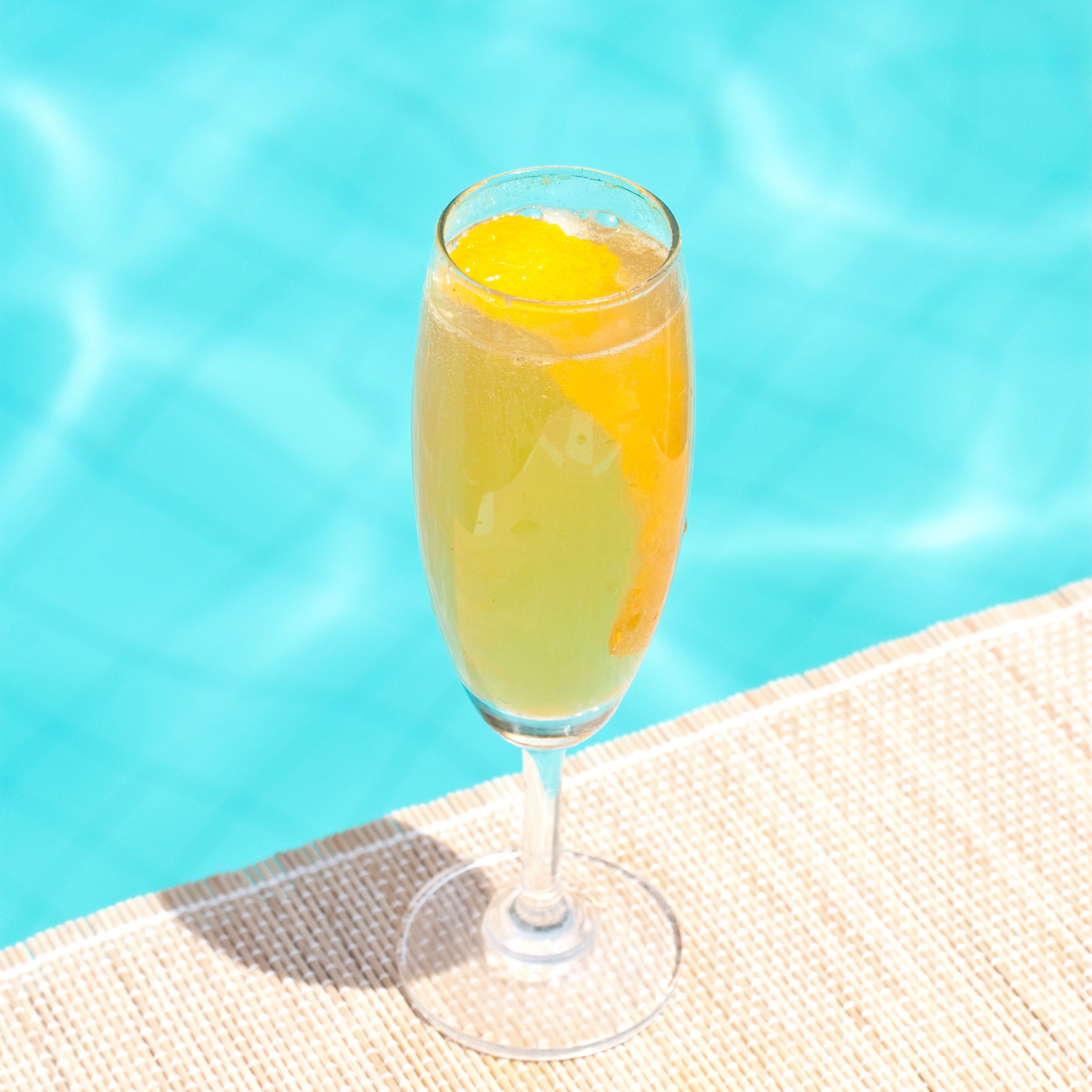 mimosa classic cocktail near waterpool on the mat
