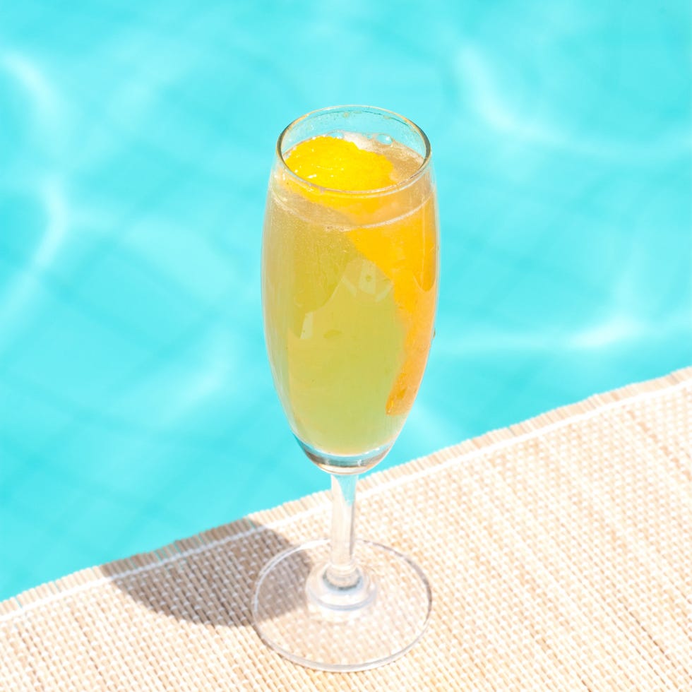 mimosa classic cocktail near waterpool on the mat
