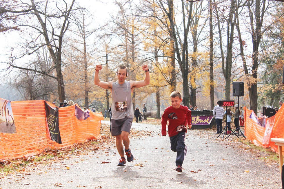 a man and a child celebrating after finishing a race mike lasusa running how running changed me runner's world
