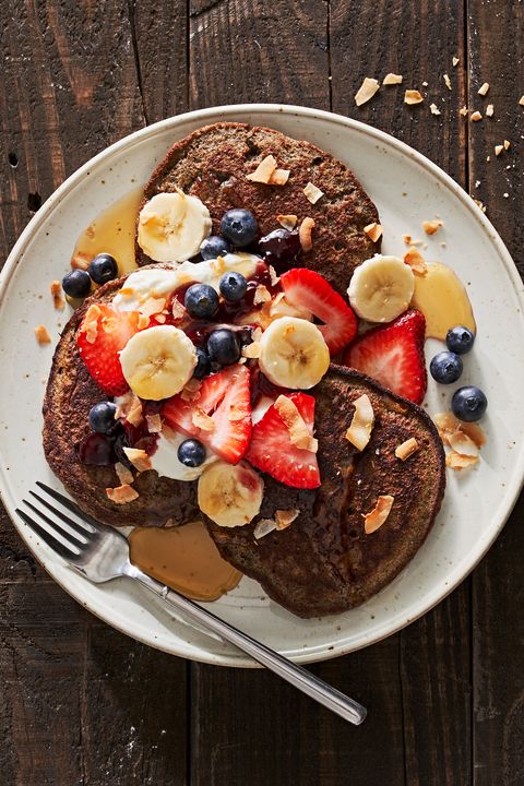 buckwheat pancakes topped with fruit, yogurt, jam, and syrup