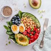 buddha bowl with avocado, egg, chickpeas, tomato, cucumber, spinach and blueberries