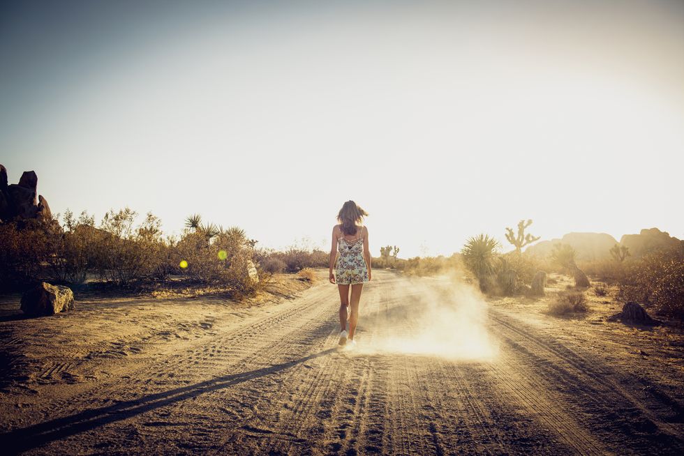 Hispanic woman walking on dirt road