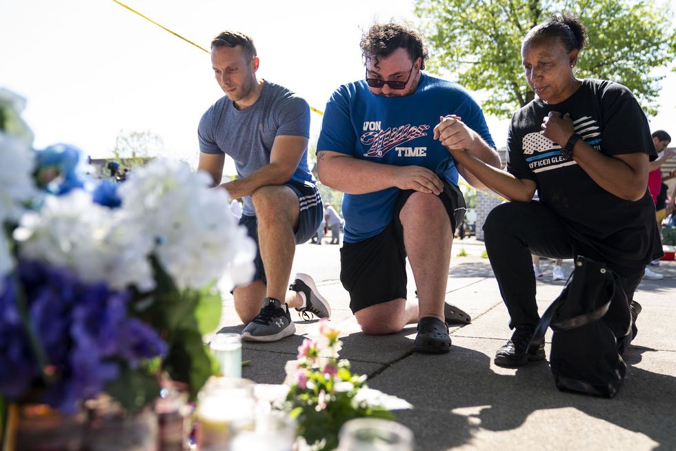buffalo, ny   may 15 joe canepa, of buffalo, william burke, of tonawanda, and jeanne legall, of buffalo, kneel and pay their respects at a memorial across the street from the tops friendly market at jefferson avenue and riley street, where 10 people were killed by what authorities are describing as an act of racially motivated violent extremism, on sunday, may 15, 2022 in buffalo, ny kent nishimura  los angeles times via getty images
