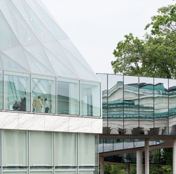 il prospetto vetrato accanto al ponte in superficie riflettente che riflette la sede storica del museo