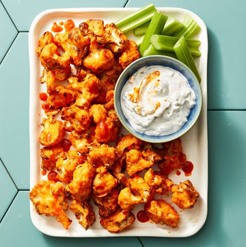 buffalo cauliflower bites on a blue tile background