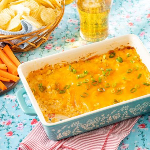 easy buffalo chicken dip in blue casserole with glass of beer