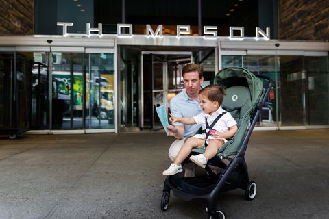man and his son in a bugaboo stroller outside the thompson hotel in new york