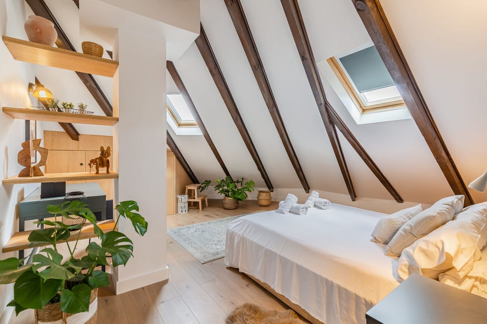 dormitorio abuhardillado con vigas vistas de madera