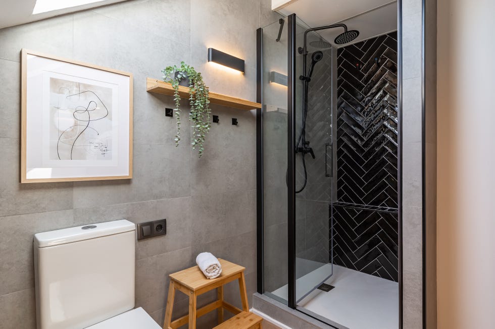 baño abuhardillado con ducha y azulejos negros en espiga