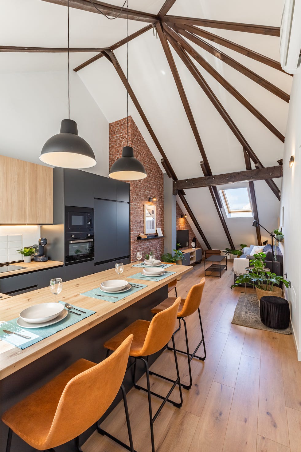 cocina moderna con barra de madera y armarios negros sin tiradores