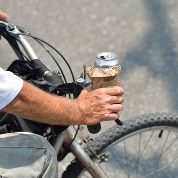 A cyclist with a beer in his hand. 