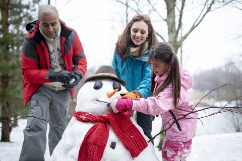 building a snowman with her family