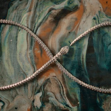 a silver necklace arranged in an infinity shape on a marbled surface a silver necklace arranged in an infinity shape on a marbled surface
