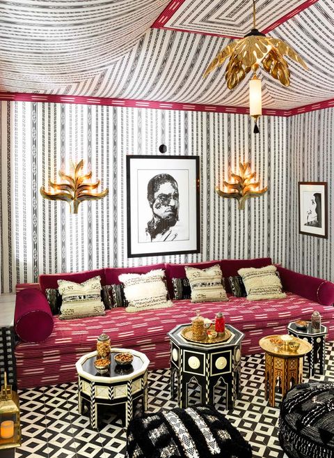 Tented screening room with large red sofa moroccan-tile tables and geometric rug 