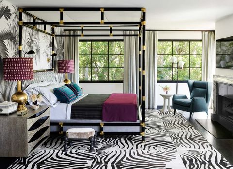 Bedroom with large windows, 4-poster bed, and zebra-pattern rug