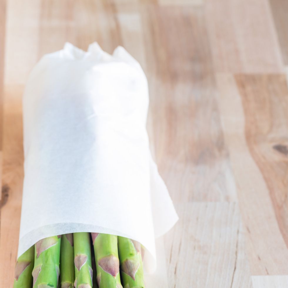 bunch of fresh green asparagus on wooden table, vertical, copy space