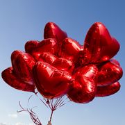 a bunch of red heart shaped balloons
