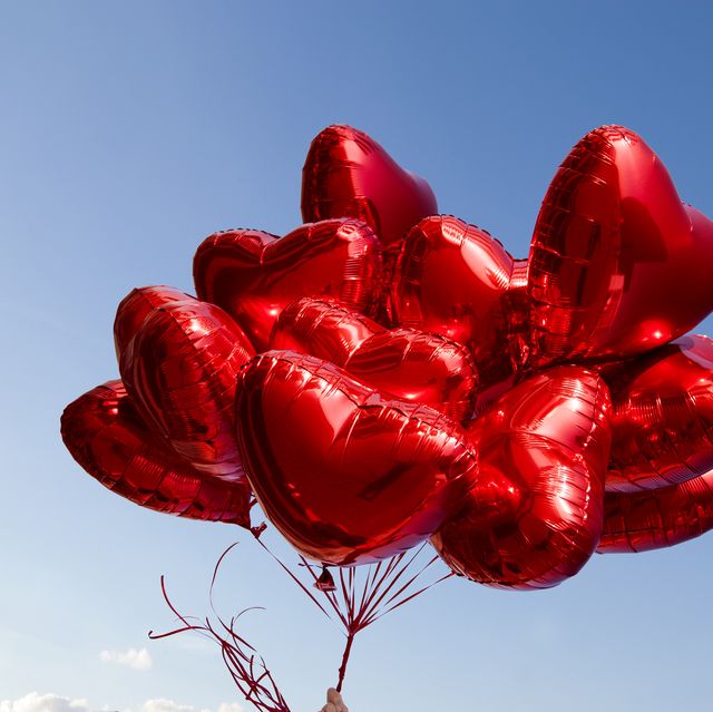 a bunch of red heart shaped balloons