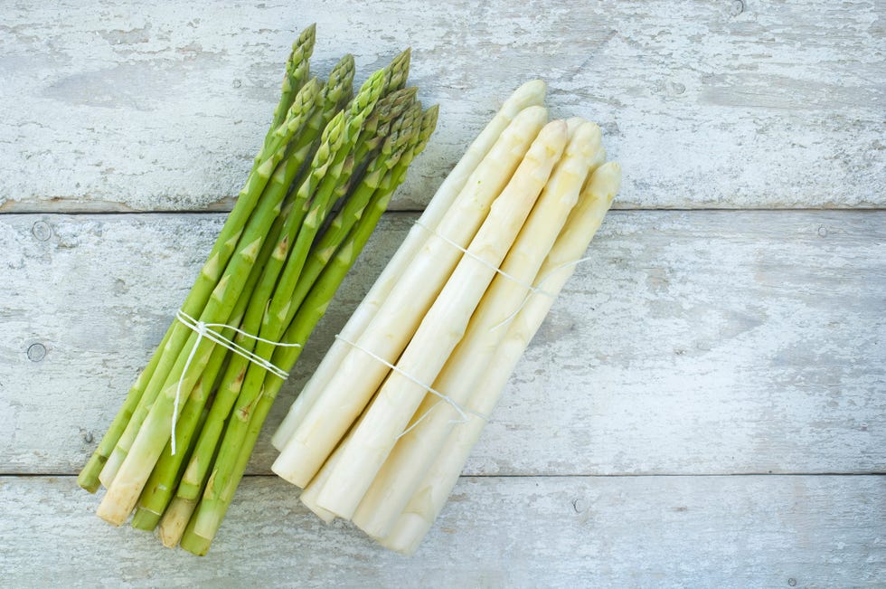 Bunches of green and white asparagus on wood