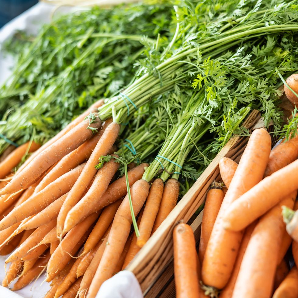 bundles of carrots in crates at the farmer's market