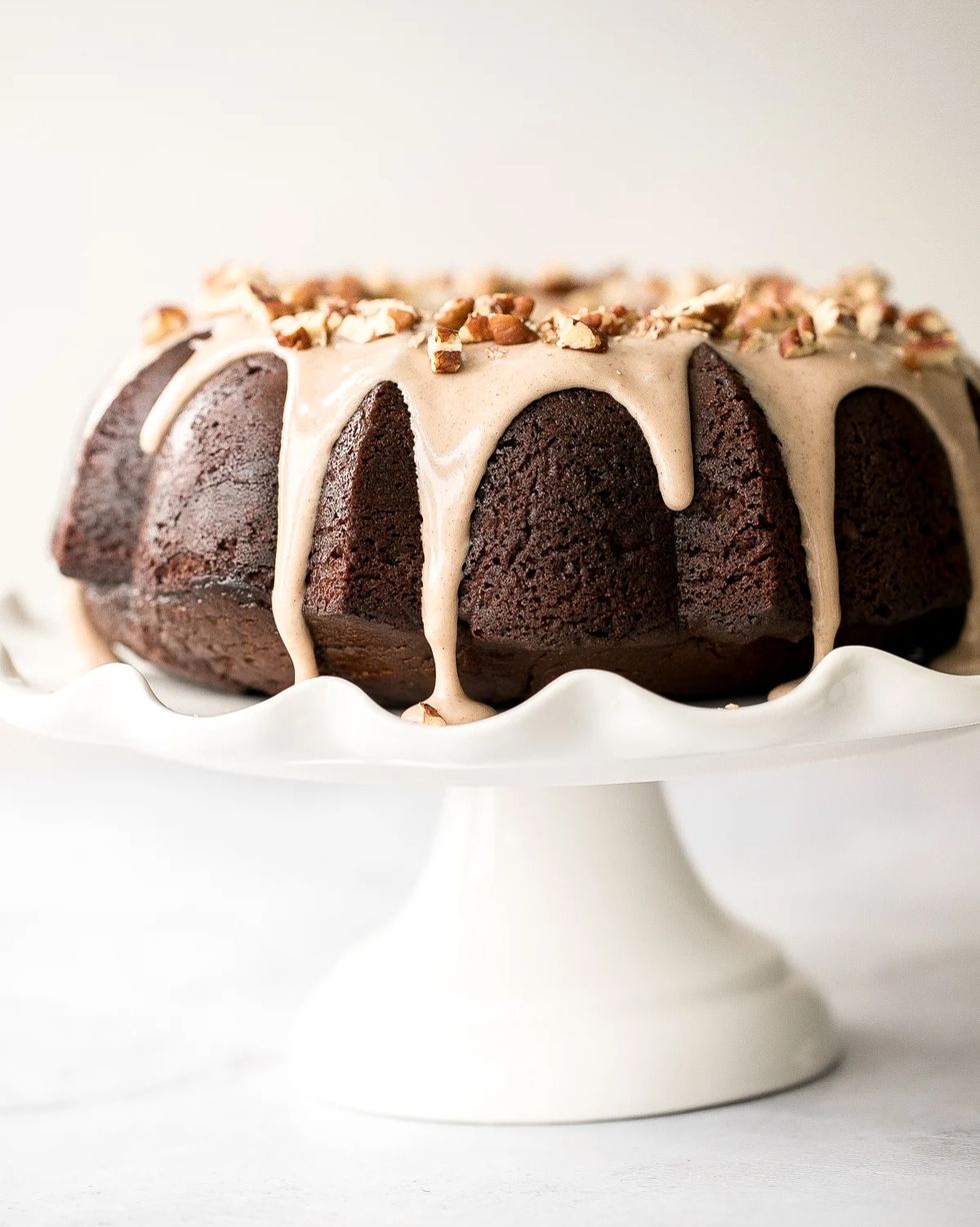 gingerbread bundt cake with maple cinnamon glaze on white cake stand