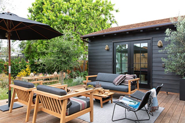 bungalow de madera en color negro con zona de asientos en la terraza
