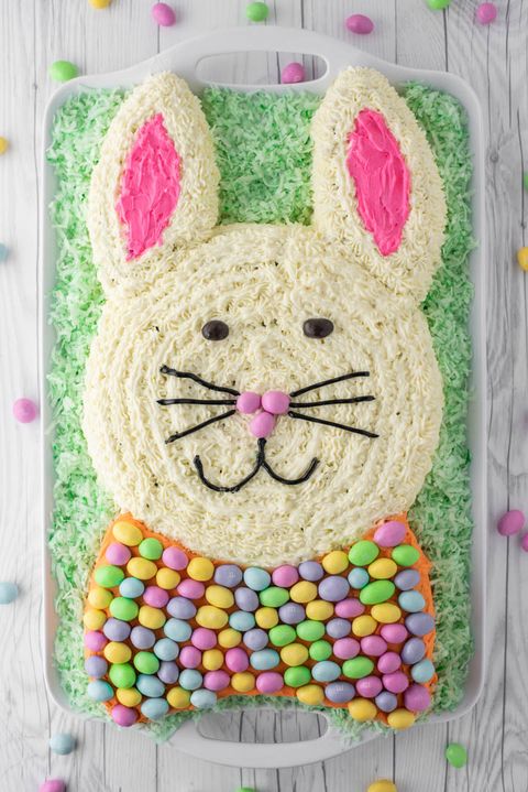 easter bunny carrot cake shaped like a bunny head with ears and a bow covered in m and m eggs