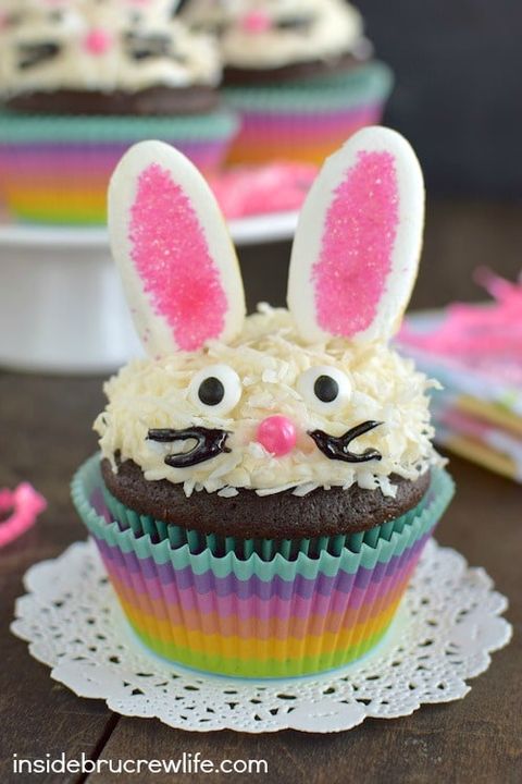 chocolate cupcakes with frosting covered in shredded coconut and decorations to look like a bunny