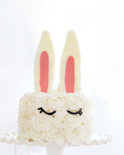 layer cake with bunny ears sticking out of the top and eyes piped on the side