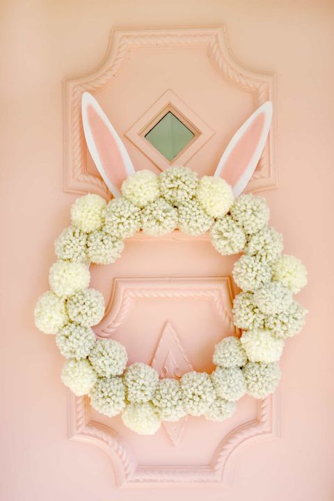 pom pom wreath with bunny ears on front door