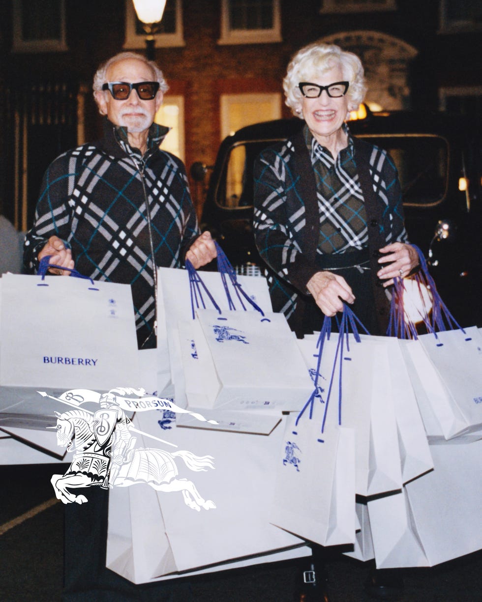 two individuals holding multiple burberry shopping bags