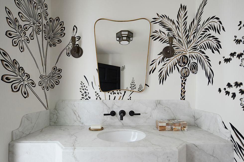 a bathroom with a large mirror and wallpaper