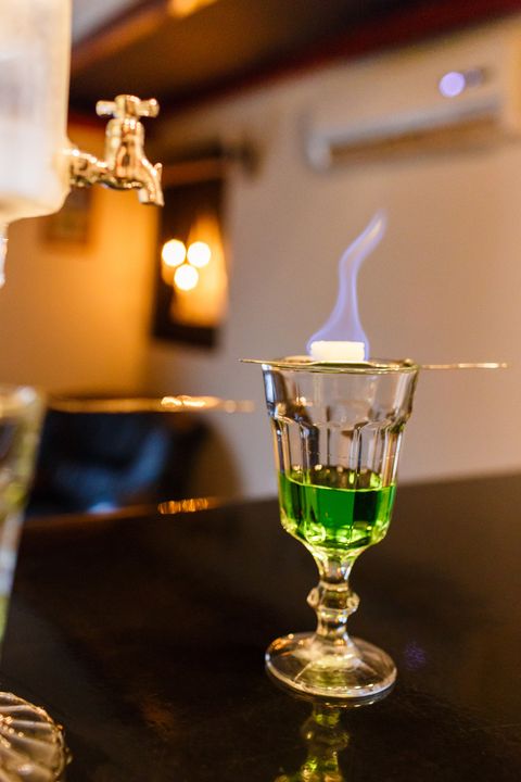 burning sugar cube on slotted spoon to prepare one dose of absinthe