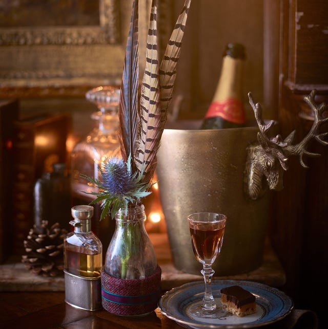 a rustic setting featuring a glass of drink flowers in a bottle and a dessert a rustic setting featuring a glass of drink flowers in a bottle and a dessert