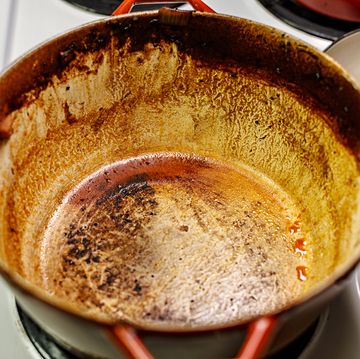 burnt food residue in dutch oven cooking pan on stove