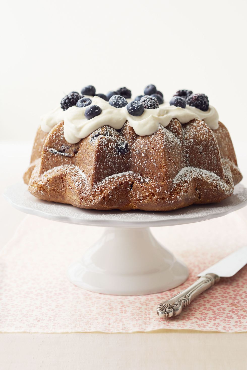 lemon curd bundt cake with frosting and blueberries on top