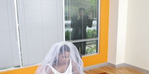 business bride working on  a laptop groom outdoors looking in