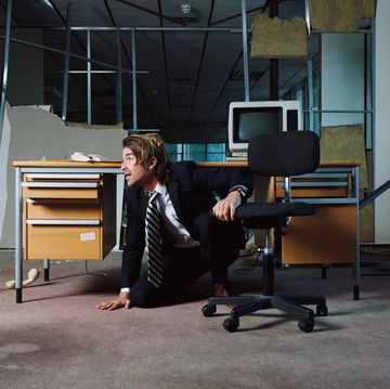 businessman emerging from under desk