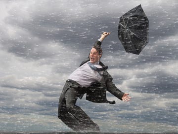 man in pak met paraplu met harde wind waar komt de wind vandaan